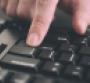 Person typing on a keyboard and pressing Enter key